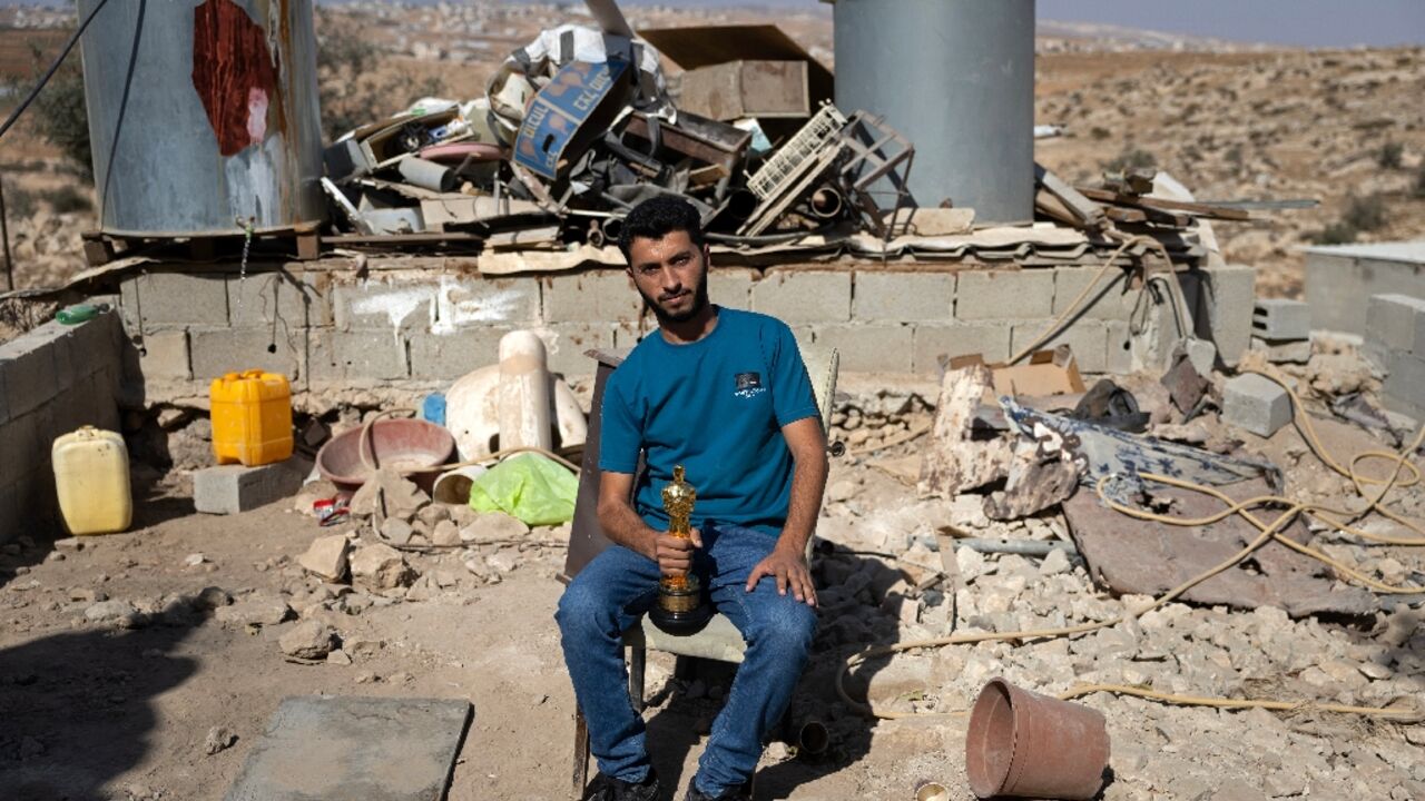 Basel Adra holds up his Oscar in the village of At Tuwani in the occupied West Bank