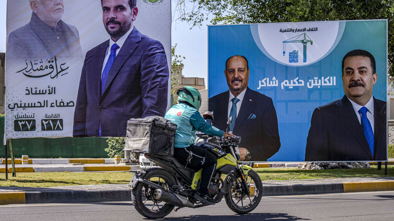 A delivery person rides a motorcycle past election billboards for candidates and blocs competing in Iraq's upcoming November parliamentary election, including incumbent Prime Minister Mohammed Shia al-Sudani, displayed along a street in Baghdad on Oct. 3, 2025. 