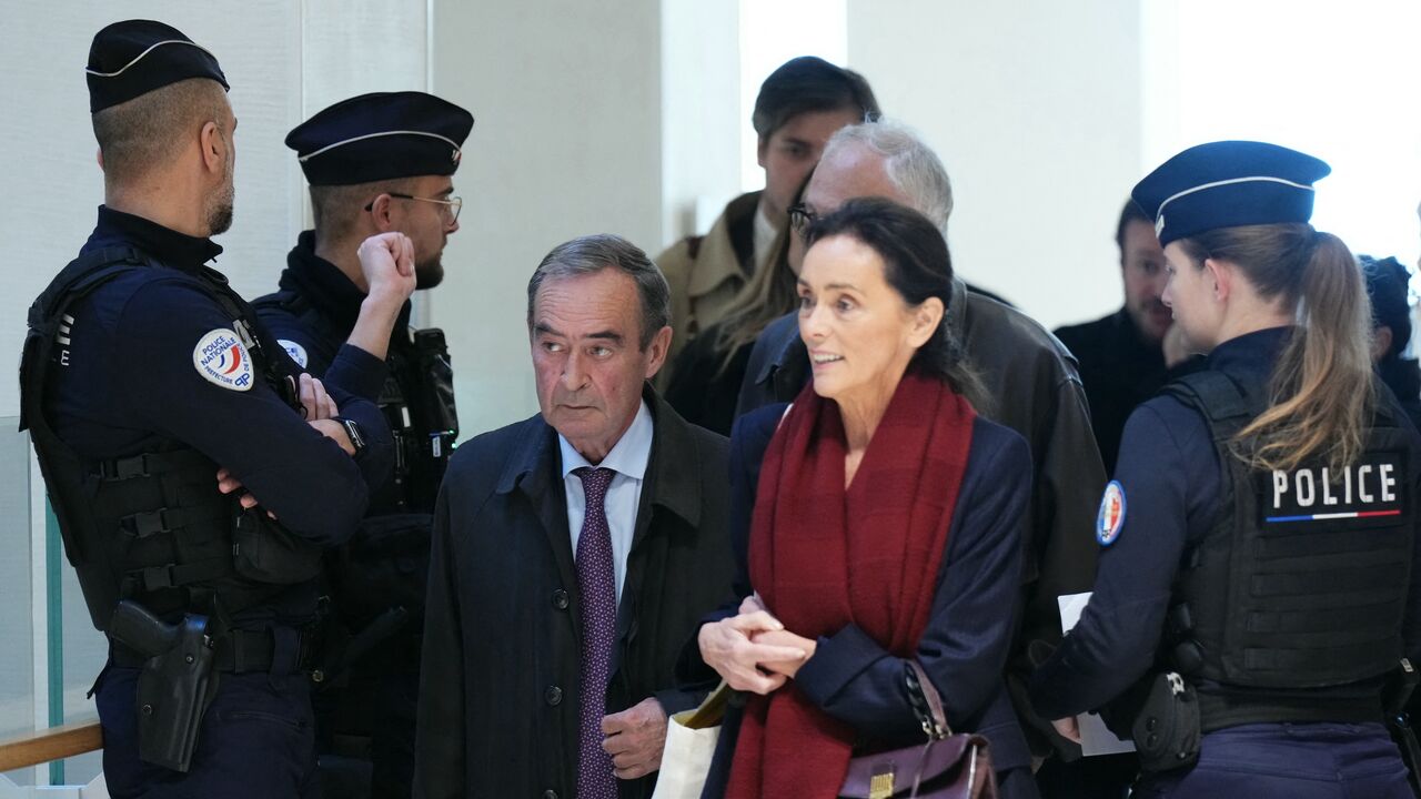 Former Director General of Lafarge Bruno Lafont (C) and French lawyer Jacqueline Laffont arrive on the opening day of the trial.