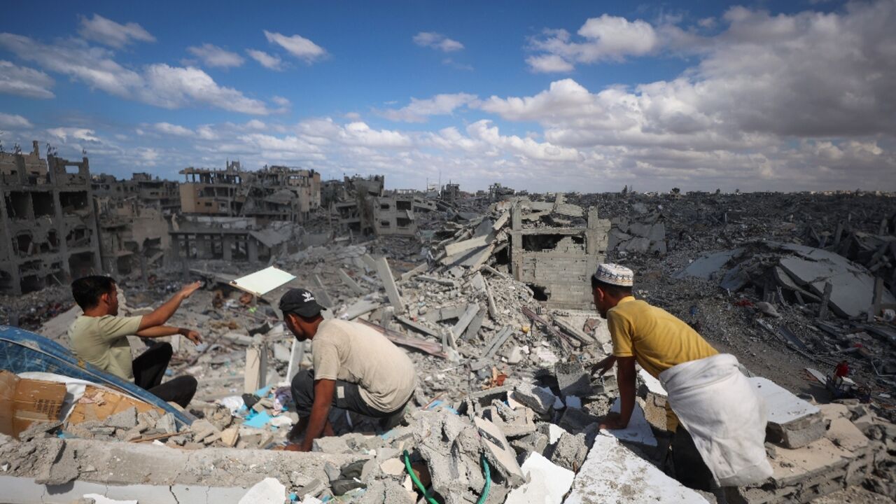 Palestinians search the rubble of buildings in Khan Yunis in the southern Gaza Strip