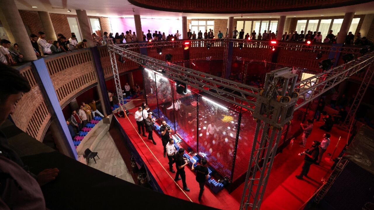 Engineering students and guests watch robots battle it out at Iran's Tech Olympics