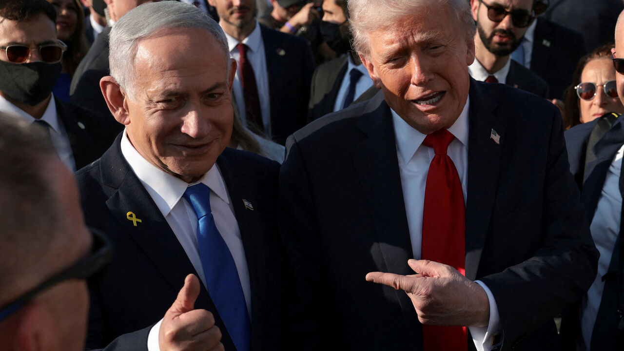 FILE PHOTO: U.S. President Donald Trump  gestures next to Israeli Prime Minister Benjamin Netanyahu at Ben Gurion International Airport in Lod, Israel, October 13, 2025. REUTERS/Evelyn Hockstein/File Photo