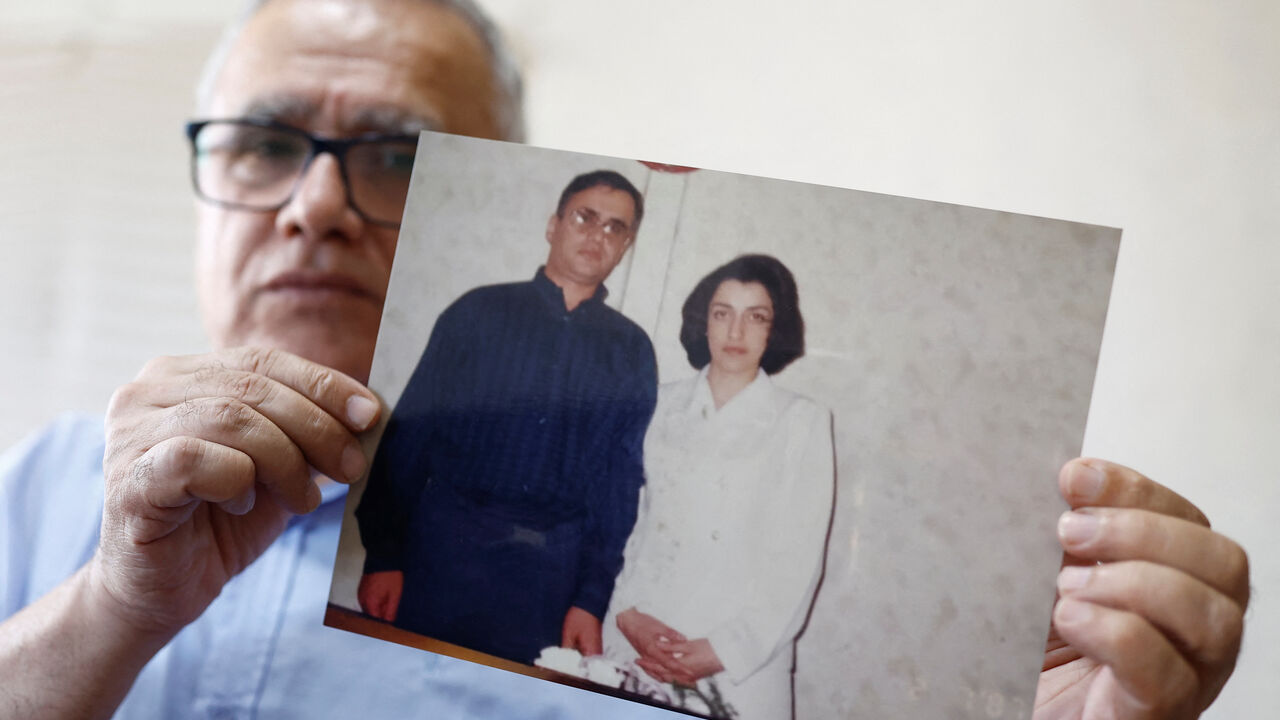 Taghi Ramahi, husband of Narges Mohammadi, a jailed Iranian women's rights advocate, who won the 2023 Nobel Peace Prize, poses with an undated photo of himself and his wife, during an interview at his home in Paris, France, October 6, 2023. REUTERS/Christian Hartmann