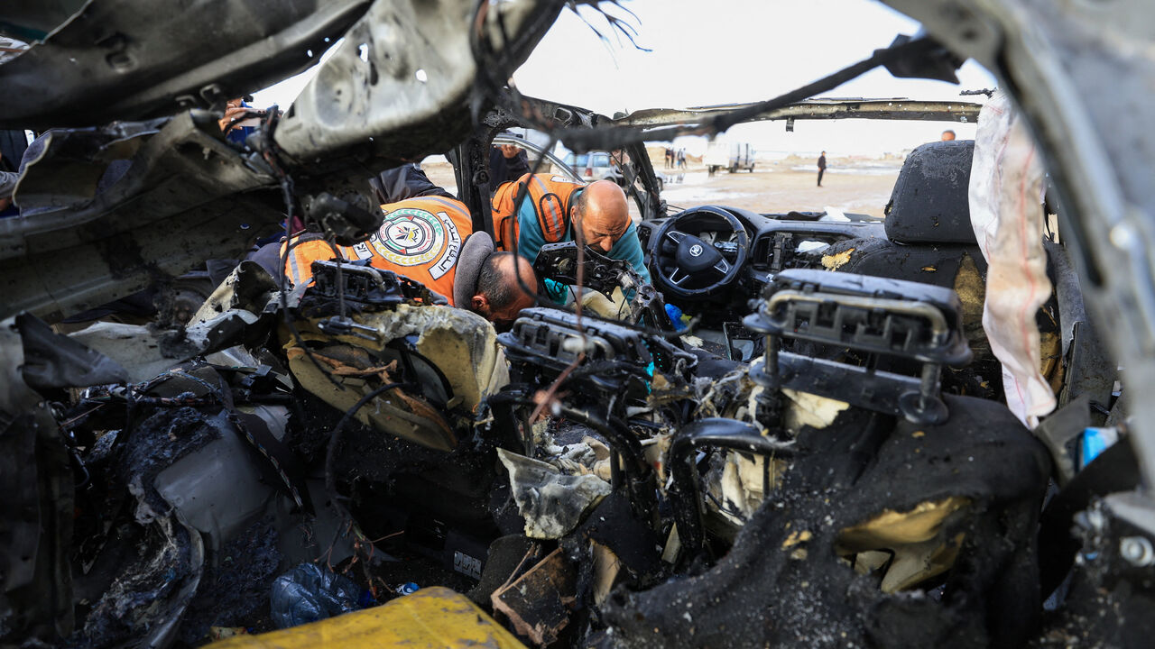 Palestinians inspect the site of an Israeli strike on a car in Gaza City, December 13, 2025.REUTERS/Dawoud Abu Alkas