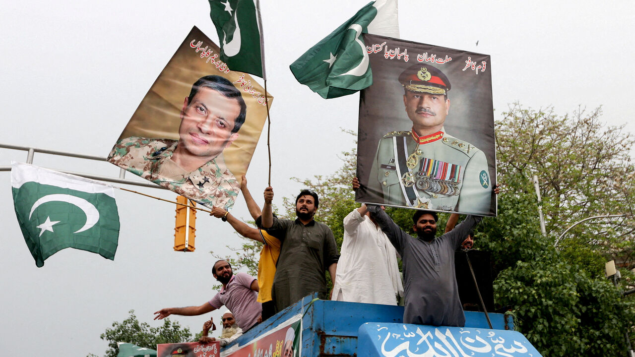 FILE PHOTO: People carry posters showing the pictures of Chief of Army Staff of Pakistan Asim Munir, (R) along with Ahmed Sharif Chaudhry, Director General of Inter-Service Public Relations wing of Pakistan Armed Forces, as they take part in a rally in support of Pakistan Army, day after the ceasefire announcement between India and Pakistan, in Lahore, Pakistan, May 11, 2025. REUTERS/Mohsin Raza/File Photo
