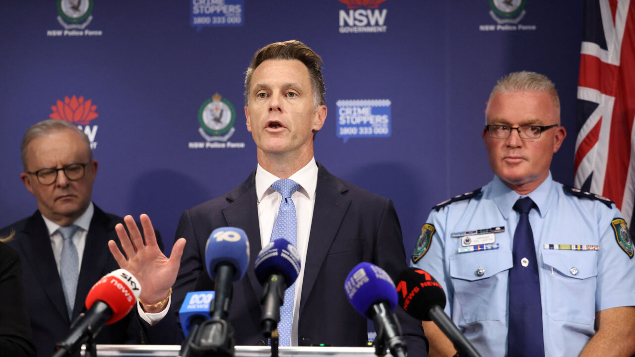 Australian Prime Minister Anthony Albanese and NSW Police Commissioner Mal Lanyon stand behind NSW Premier Chris Minns as he speaks during a press conference at NSW Police headquarters, following a deadly shooting incident during a Jewish holiday celebration at Bondi Beach, in Sydney, Australia, December 16, 2025. REUTERS/Hollie Adams