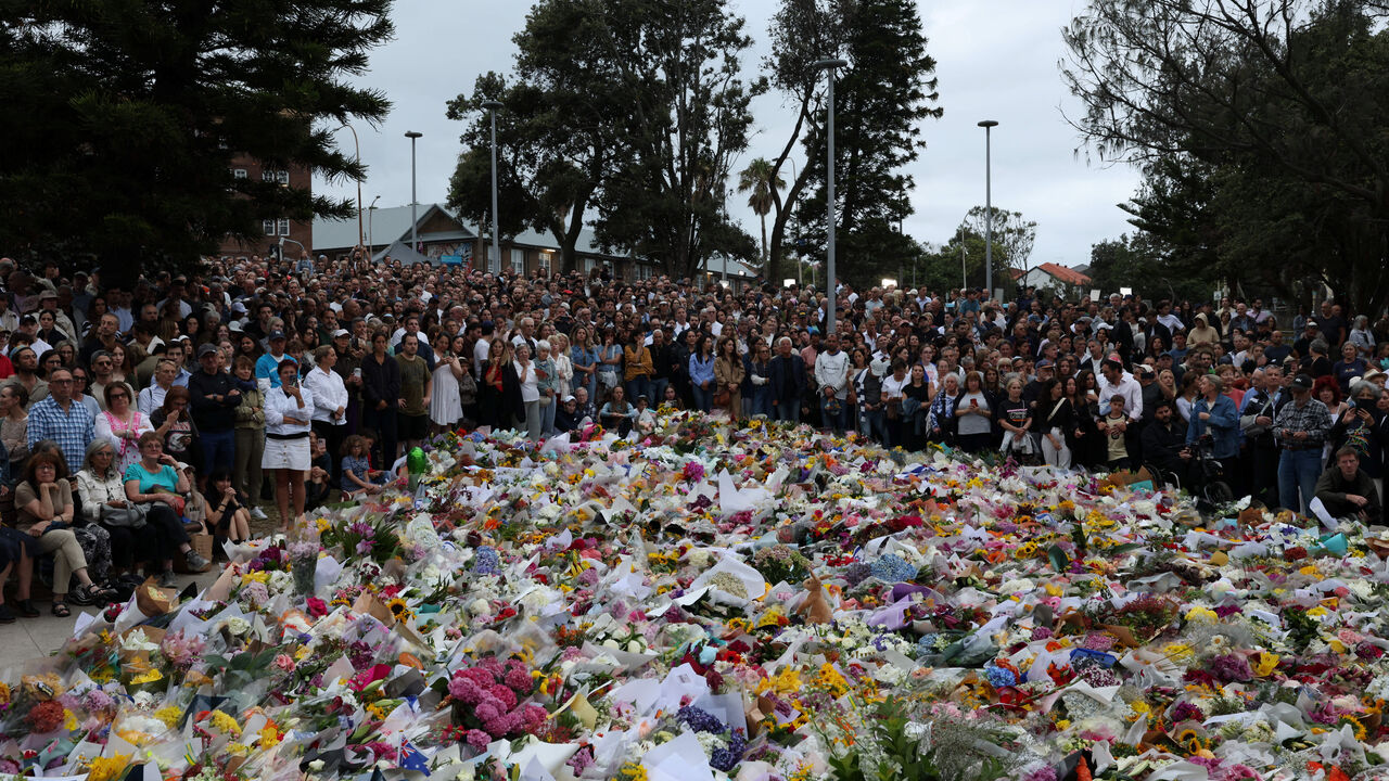 People lay flowers and pay tributes at Bondi Beach to honour the victims of a mass shooting that targeted a Jewish Holiday celebration on Sunday at Bondi Beach, in Sydney, Australia, December 16, 2025. REUTERS/Hollie Adams
