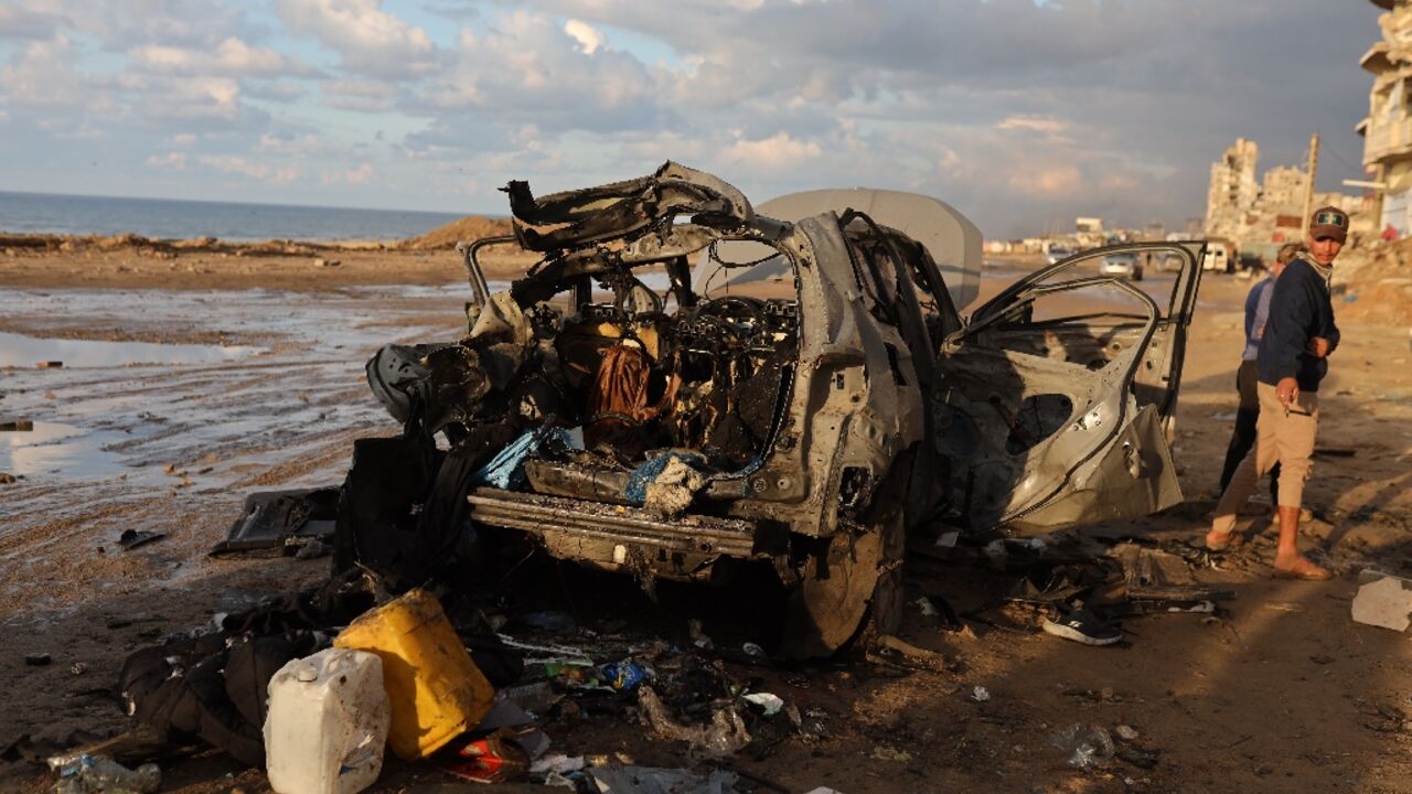 Palestinians inspect the site of the Israeli strike
