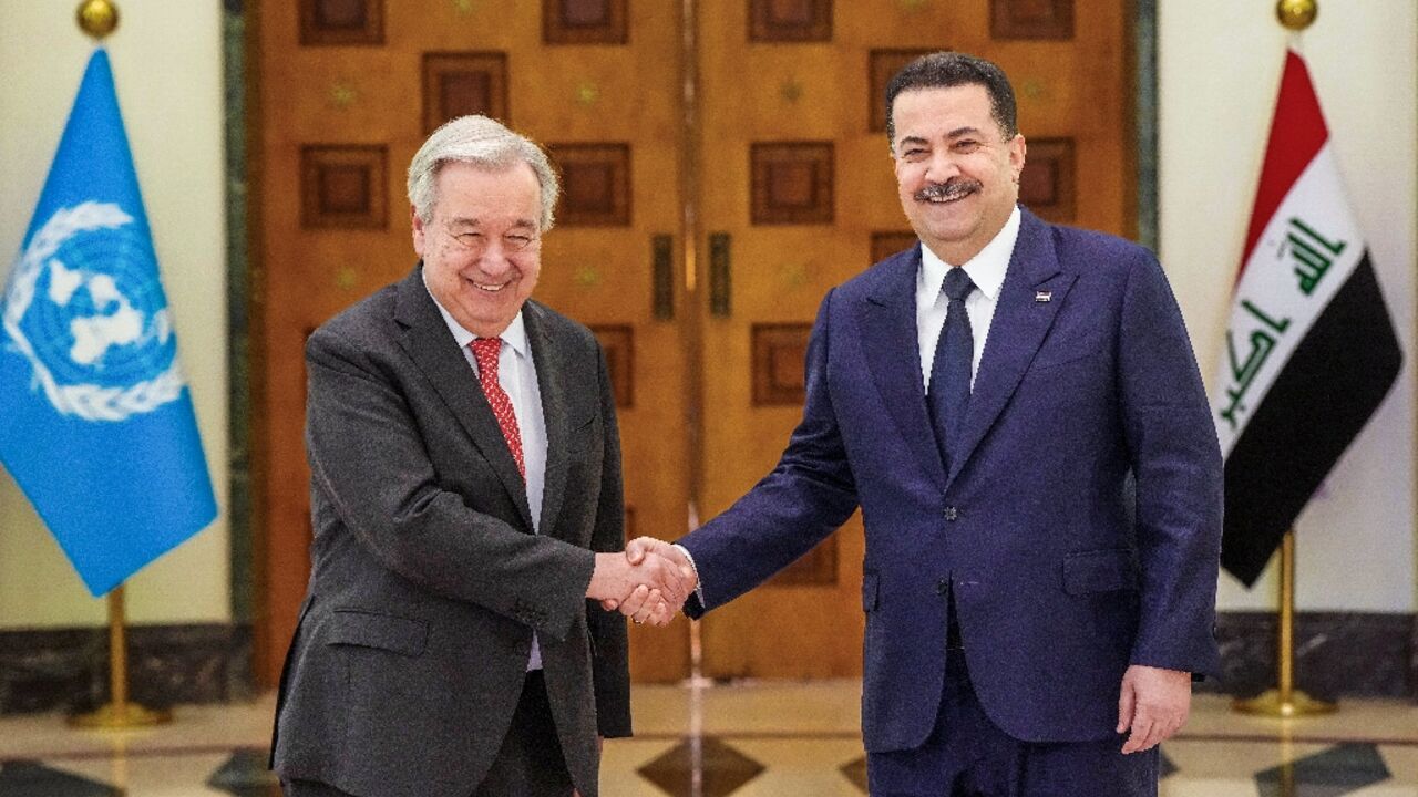 This handout picture released by the office of Iraq's Prime Minister Mohammed Shia al-Sudani shows him shaking hands with United Nations Secretary-General Antonio Guterres during a meeting in Baghdad