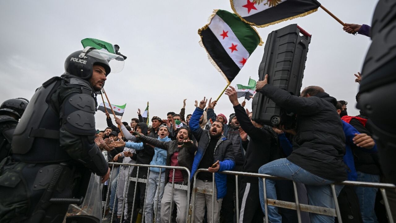 Syrians celebrate the anniversary of the toppling of longtime ruler Bashar al-Assad in Damascus