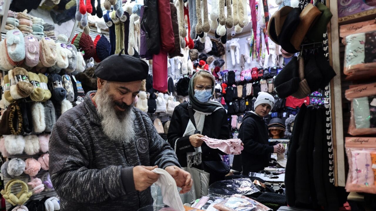 A shopkeeper tidies his stall in Tajrish Bazaar in the Iranian capital. Some traders have protested the rising price of imports as the rial falls against the dollar