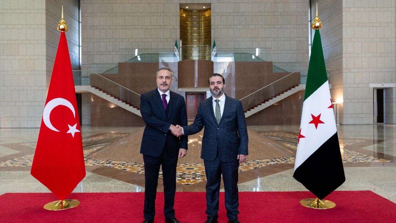This handout photograph provided by the Turkish Foreign Ministry press service shows Turkish Foreign Minister Hakan Fidan meeting with his Syrian counterpart Asaad al-Shaibani in Damascus