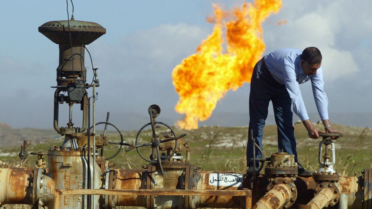 A worker turns a valve at the Shirawa oil field, where oil was first pumped in Iraq in 1927, outside the northern city of Kirkuk, Jan. 19, 2004.