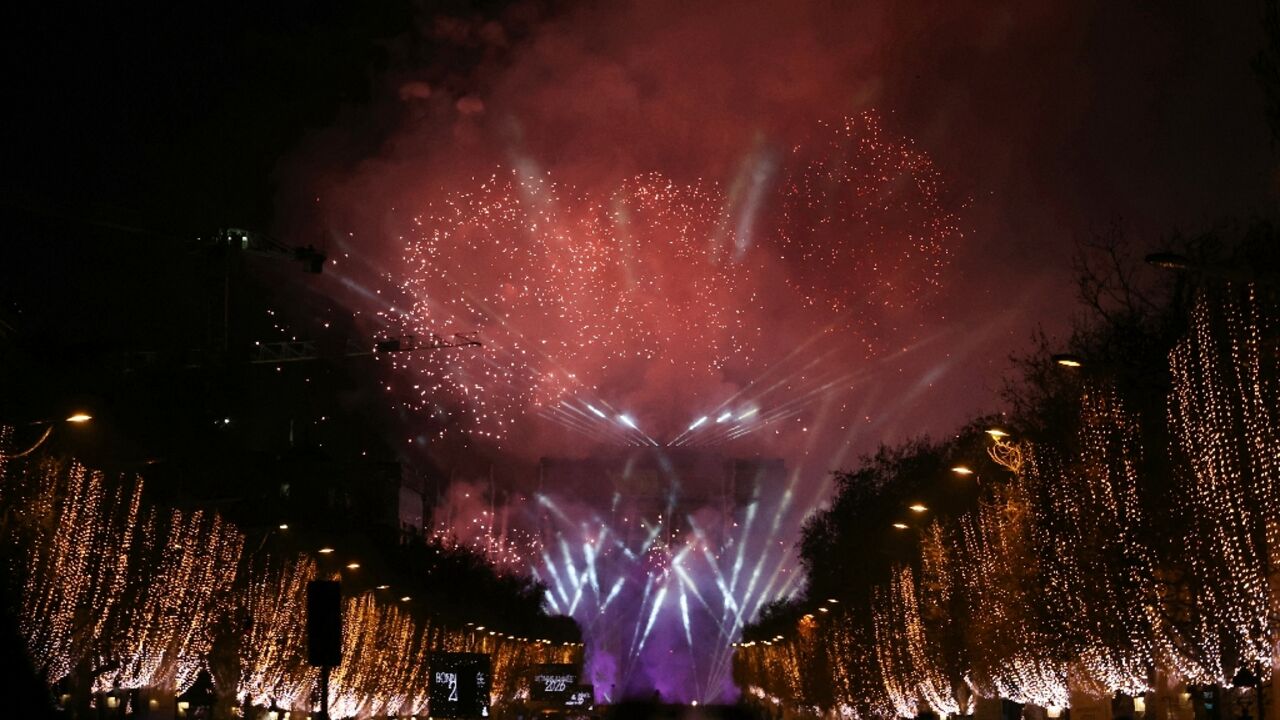 Fireworks explode in the sky over the Arc de Triomphe in Paris
