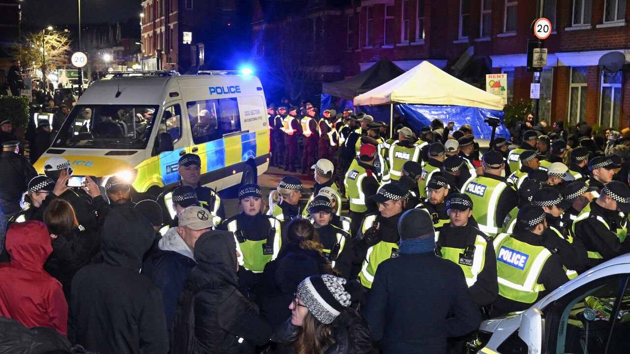 People stand in front of police officers near a Kurdish community centre after a counter terrorism investigation into suspected activity linked to the banned Kurdistan Workers Party, known as the PKK, in London, Britain, November 27, 2024. REUTERS/Jaimi Joy/File Photo