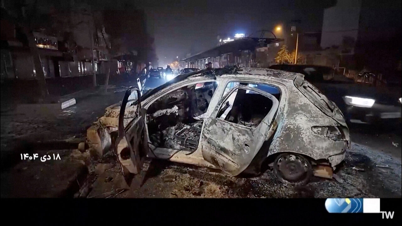 A burnt car lies on the road following unrest sparked by dire economic conditions, in a place given as Tehran, Iran, January 10, 2026, in this screengrab from Iran's state media broadcast footage. IRIB via WANA(West Asia News Agency) via REUTERS