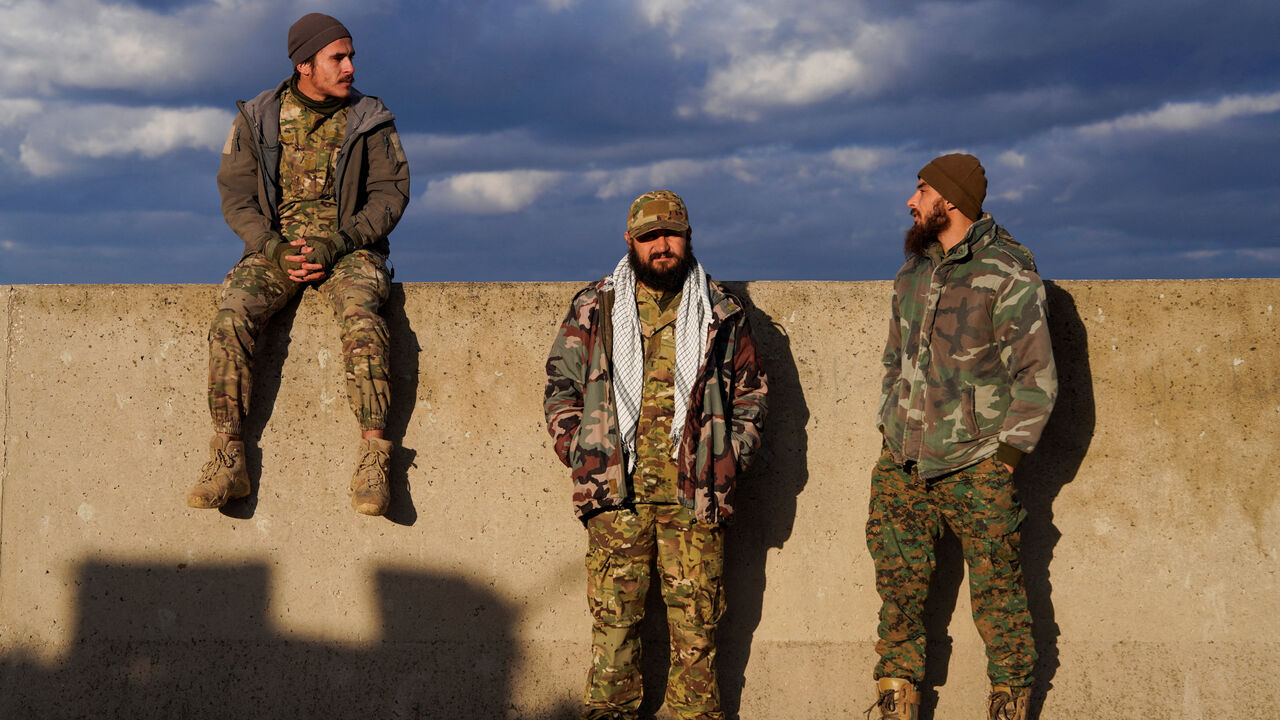 Members of the Syrian army stand together, as Syrian state agency, SANA, reported on Wednesday that the Syrian army sent reinforcements from Latakia to "Deir Hafer front", amid escalating tensions and threats from the Syrian government to launch an offensive against Kurdish-led Syrian Democratic Forces (SDF), in Latakia, Syria, January 14, 2026. REUTERS/Karam al-Masri