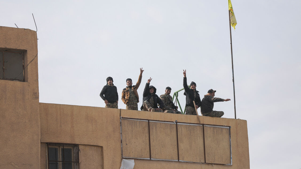 Members of the Kurdish-led Syrian Democratic Forces (SDF) gesture in Deir al-Zor, after U.S.-backed alliance led by Syrian Kurdish fighters captured Deir el-Zor, the government's main foothold in the vast desert, according to Syrian sources, in Syria December 7, 2024. REUTERS/Orhan Qereman/File Photo