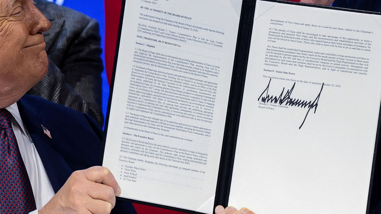 FILE PHOTO: U.S. President Donald Trump holds a signed resolution, as he attends a charter announcement for his Board of Peace initiative aimed at resolving global conflicts, alongside the 56th annual World Economic Forum (WEF), in Davos, Switzerland, January 22, 2026. REUTERS/Jonathan Ernst/File Photo