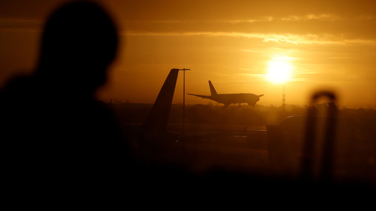 A passenger waits in departures as a British Airways plane lands at London Heathrow airport, London, Britain, November 15, 2025. REUTERS/Peter Cziborra/File Photo