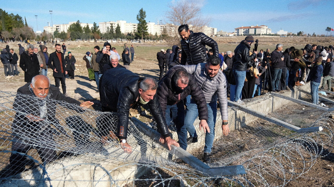 Pro-Kurdish protesters tear down a border fence as they attempt to cross to the Kurdish-controlled northeastern Syrian city of Qamishli during a demonstration in support of Syrian Kurds and against recent military clashes between the Syrian army and Kurdish forces, in Nusaybin, southeastern Turkey, January 20, 2026. REUTERS/Ensar Ozdemir