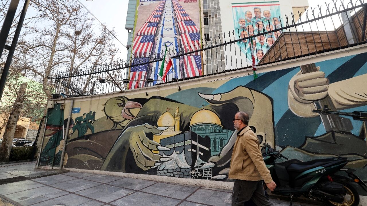 Anti-US and anti-Israel banners hang on a building in Palestine Square in Tehran 