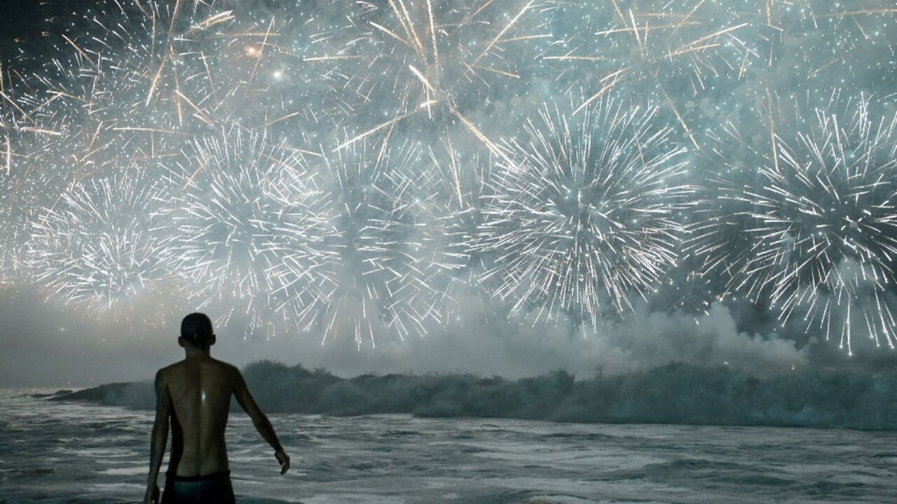 A man celebrates as he watches the traditional New Year's fireworks from the water at Copacabana Beach in Rio de Janeiro, Brazil, on January 1, 2026