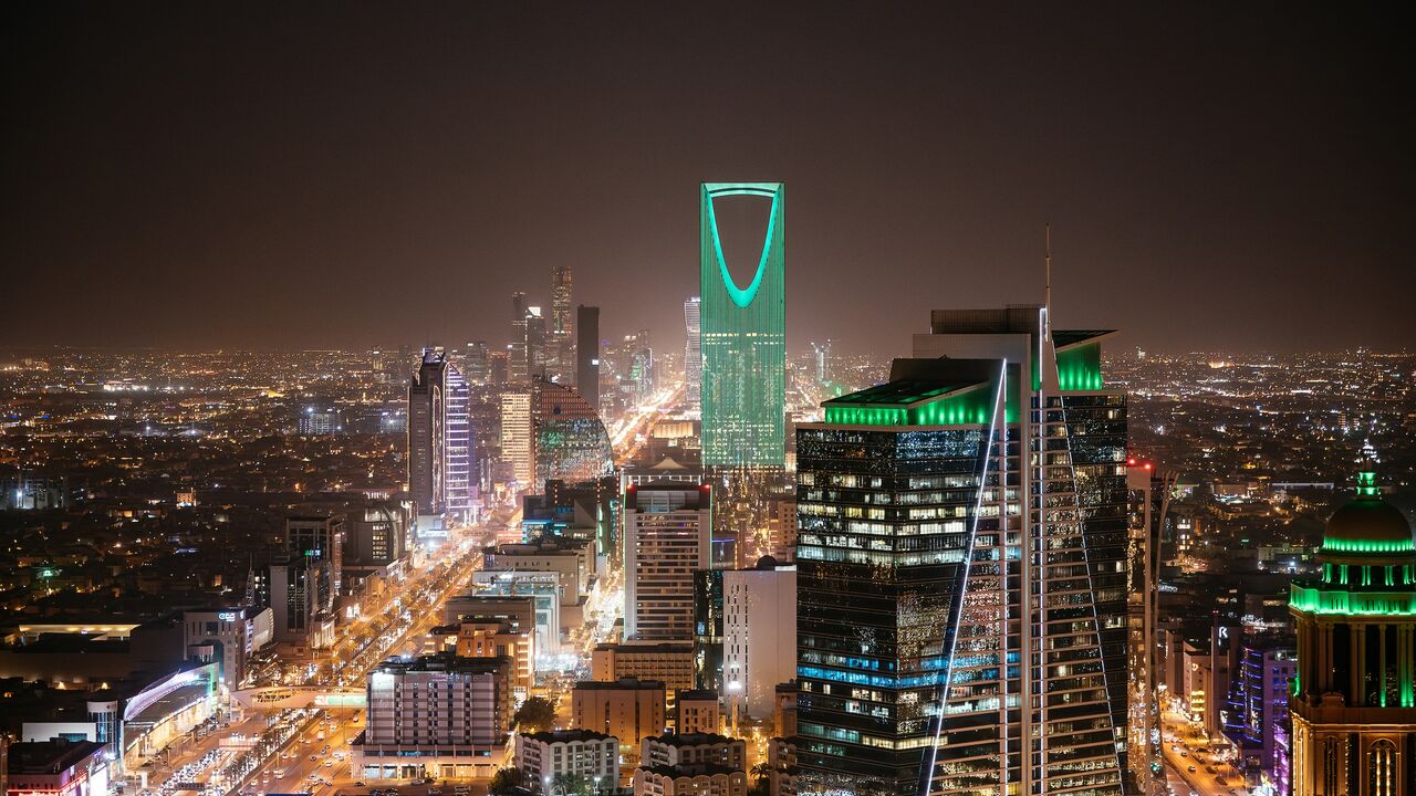 Aerial view of Riyadh at night with illuminated modern skyscrapers and busy streets under a clear dark sky, Al Olaya street.