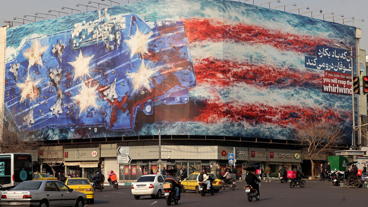 TOPSHOT - Cars drive past an anti-US billboard installed on a building at the Enqelab Square in Tehran on January 26, 2026. (Photo by ATTA KENARE / AFP via Getty Images)