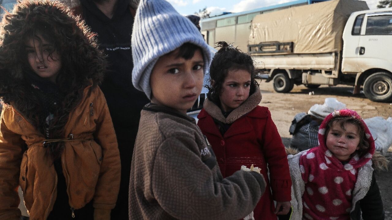 Kurdish children and their families fleeing a government advance arrive in Qamishli