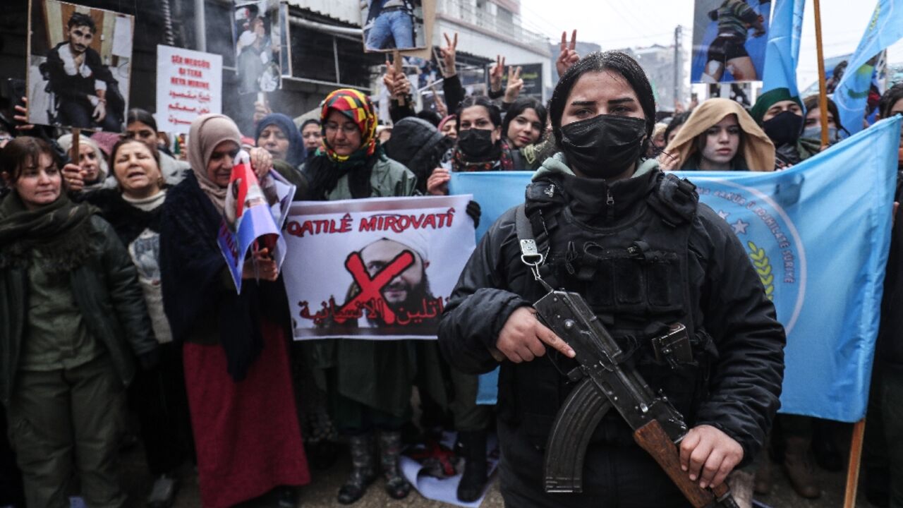 A member of the Kurdish security forces stands guard as Syrian Kurds protest against the central government in the city of Qamishli on Tuesday