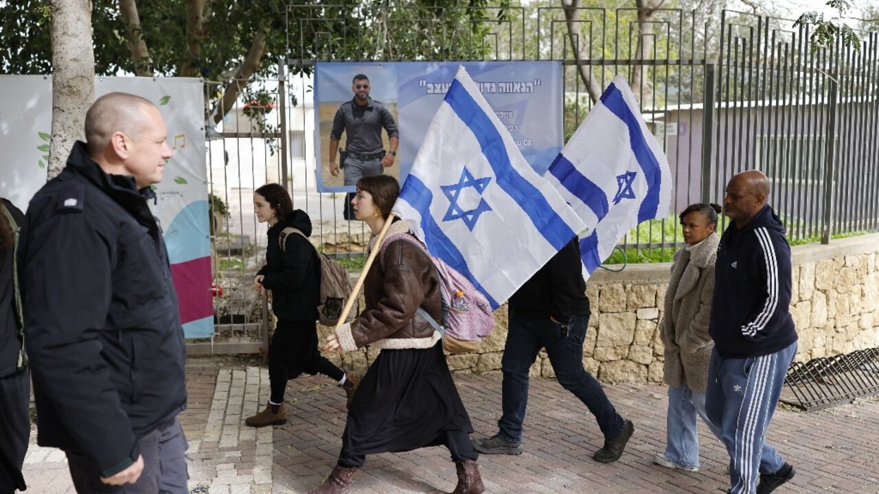 Mourners carrying Israeli flags gathered for the funeral ceremony in Meitar