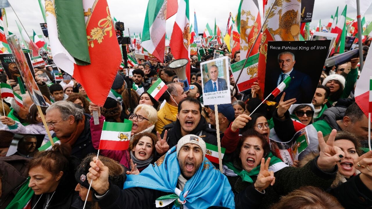 Iranian demonstrators hold flags and posters depicting Iran's former crown prince and now key opposition figure Reza Pahlavi in Munich