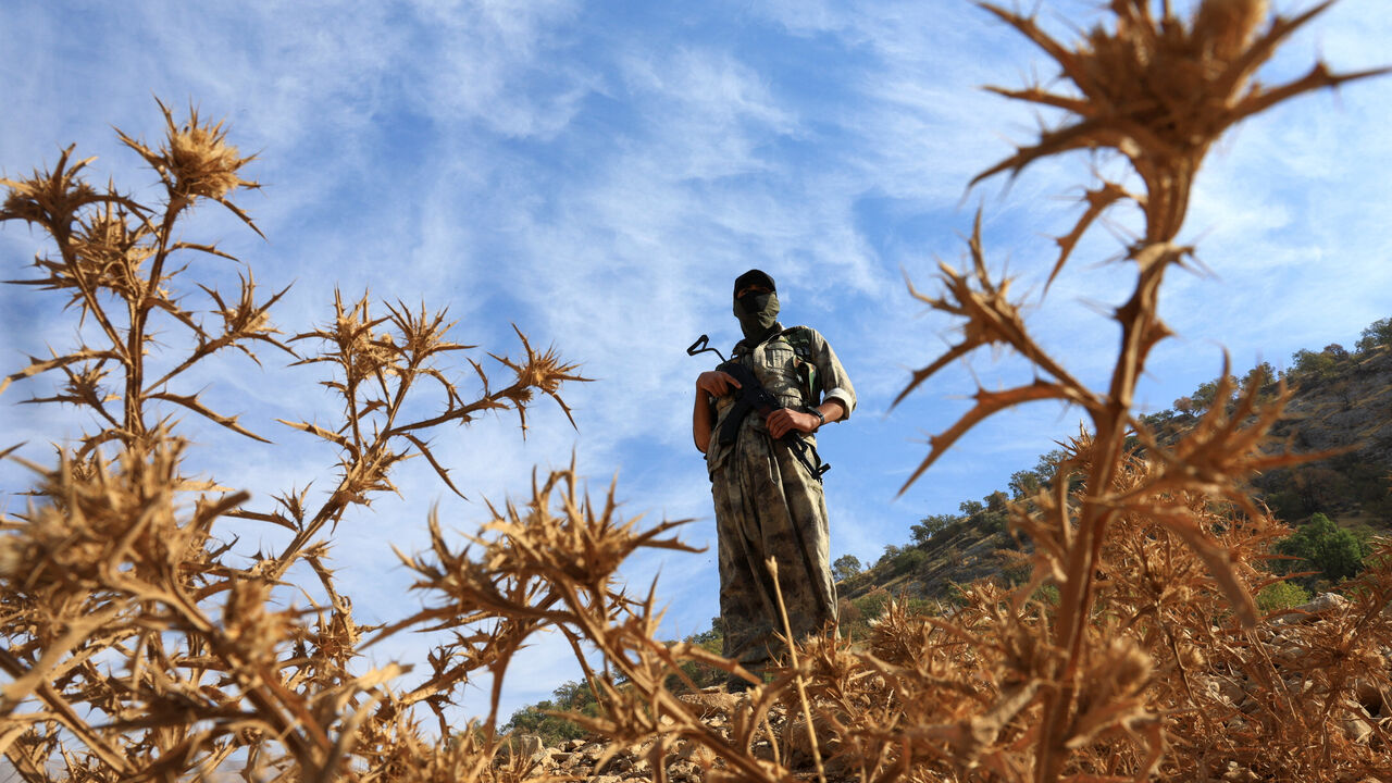 A fighter with the Kurdistan Workers' Party (PKK) stands guard during a disarmament process marking a significant step toward ending the decades-long conflict between Turkey and the outlawed group, in the Qandil mountains, Iraq, October 26, 2025. REUTERS/Thaier Al-Sudani