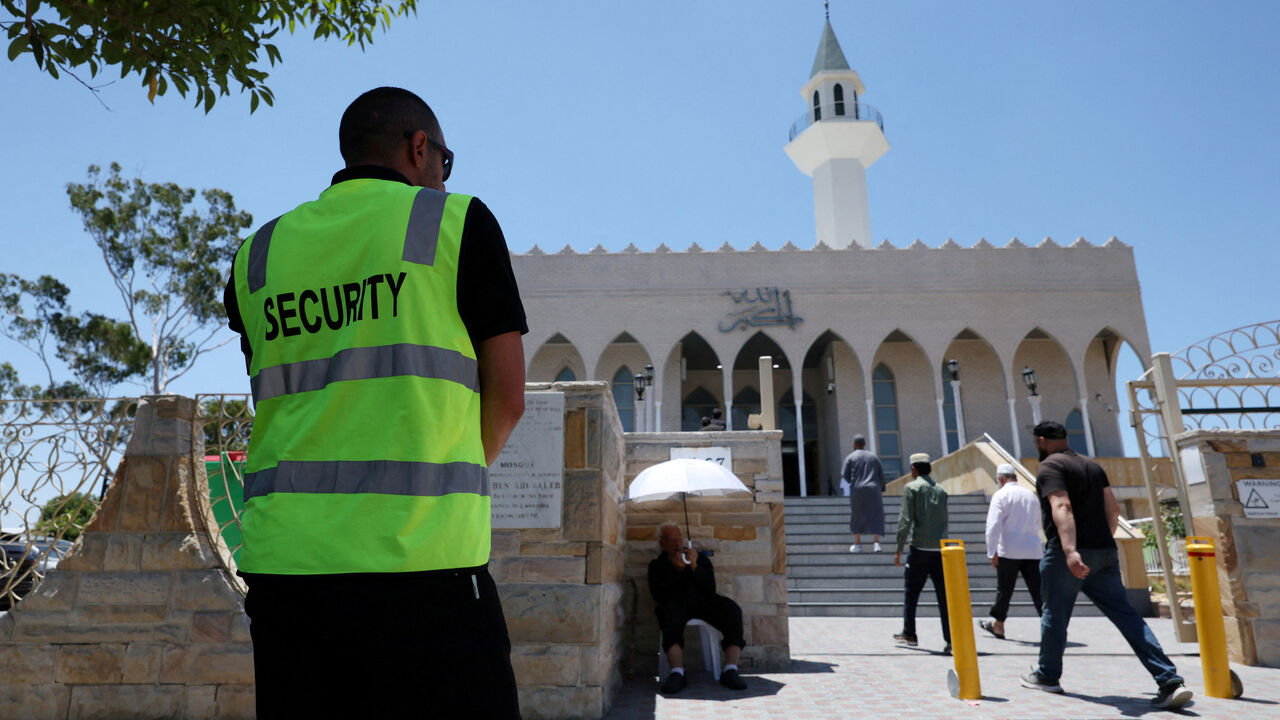 FILE PHOTO: A security guard stands outside the Lakemba Imam Ali bin Abi Talib Mosque as people arrive for Friday prayers, amid a heightened security presence following the deadly mass shooting during a Jewish Hanukkah celebration at Bondi Beach on December 14, in Sydney, Australia, December 19, 2025. REUTERS/Hollie Adams/File Photo