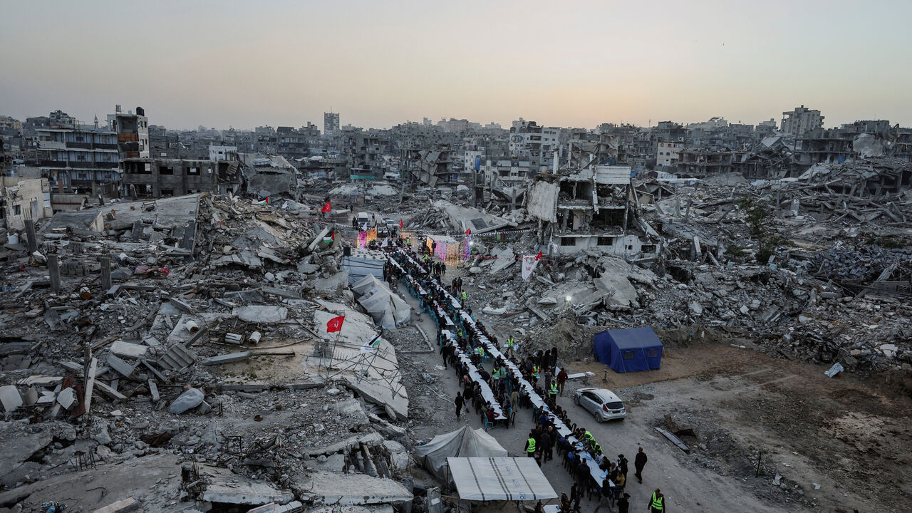 FILE PHOTO: Palestinians gather to break their fast by eating Iftar meals on the first day of the holy month of Ramadan, near the rubble of residential buildings destroyed during the two-year Israeli offensive, in Gaza City, February 18, 2026. REUTERS/Dawoud Abu Alkas/File Photo