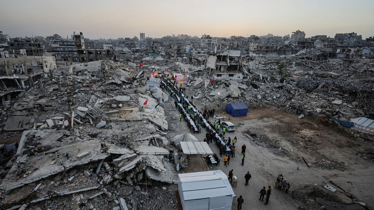 Palestinians gather to break their fast by eating Iftar meals on the first day of the holy month of Ramadan, near the rubble of residential buildings destroyed during the two-year Israeli offensive, in Gaza City, February 18, 2026. REUTERS/Dawoud Abu Alkas
