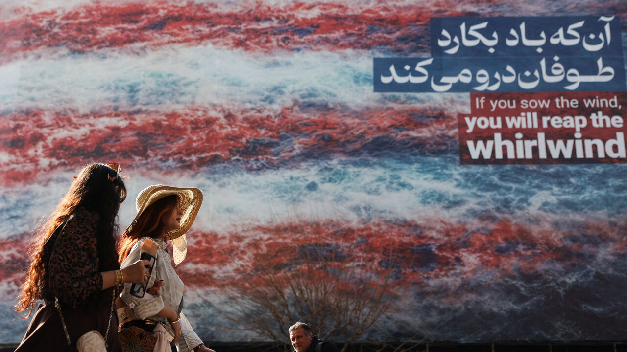 Iranian women walk past an anti-U.S. billboard in Tehran, Iran, February 19, 2026. Majid Asgaripour/WANA (West Asia News Agency) via REUTERS
