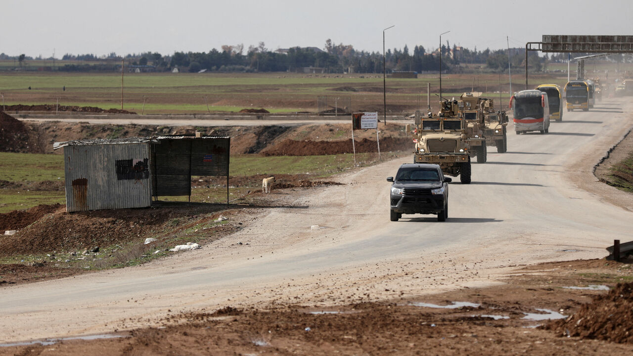 FILE PHOTO: U.S. military vehicles move ahead of buses transporting Islamic State detainees from Syria to Iraq, according to a security source from the Syrian Democratic Forces, in Qamishli, Syria, February 8, 2026. REUTERS/Orhan Qereman/File Photo