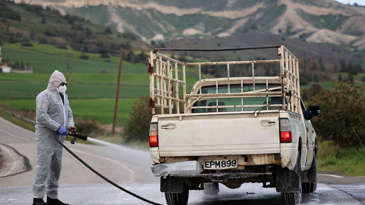 Man in a hazmat suit disinfects a vehicle and the road leading to farming units Oroklini, Cyprus, following cases of foot and mouth disease among livestock, Cyprus February 24, 2026. REUTERS/Yiannis Kourtoglou