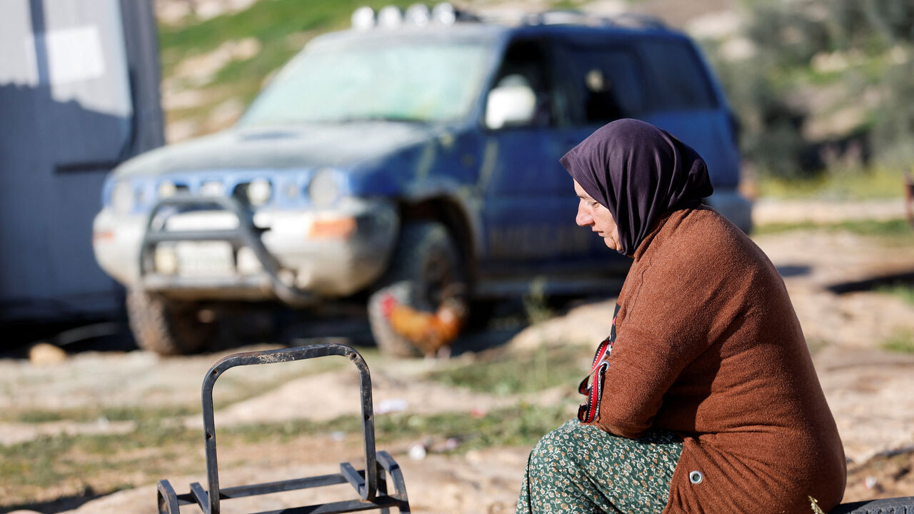 A Palestinian woman sits near a vehicle, which Palestinians say was damaged by Israeli settlers, in Susiya near Hebron in the Israeli-occupied West Bank February 25, 2026. REUTERS/Mussa Qawasma
