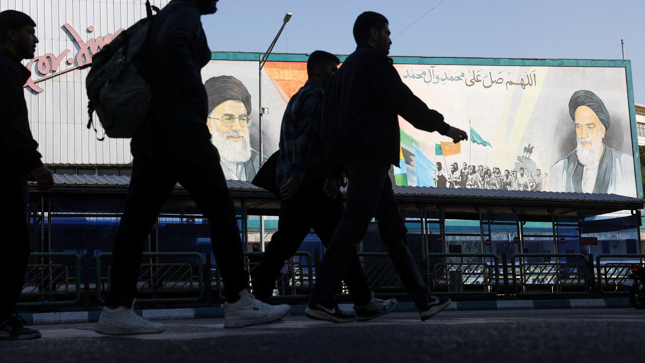 People walk near a mural featuring images of Iran's Supreme Leader Ayatollah Ali Khamenei and the leader of Iran's 1979 Islamic Revolution, Ayatollah Ruhollah Khomeini, on a street in Tehran, Iran, February 26, 2026. Majid Asgaripour/WANA (West Asia News Agency) via REUTERS