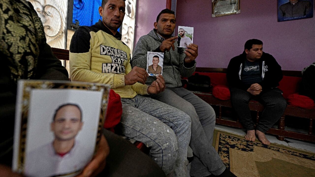Relatives holding portraits of those believed to to have gone missing while making the journey to Europe through Libya