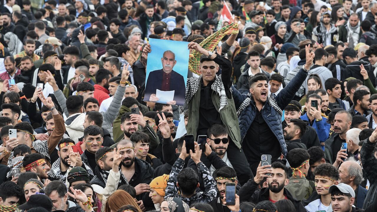 A man holds a poster of Abdullah Ocalan, Turkish-jailed founder of the Kurdistan Workers Party (PKK), during a gathering of Turkish Kurds for Nowruz celebrations in Diyarbakir, southeast Turkey, on March 21, 2025. 