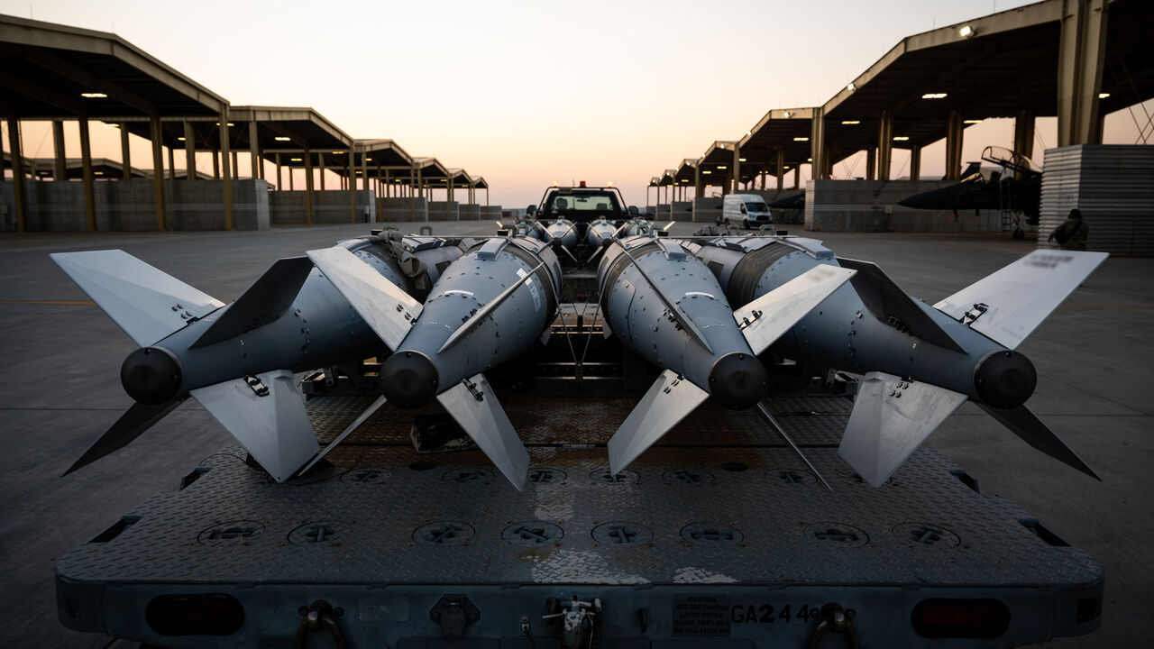 In this handout photo in an undisclosed location, US Airmen prepare to load GBU-31 munition systems onto F-15E Strike Eagles within the US Central Command area of responsibility, Dec. 18, in support of Operation Hawkeye Strike. 