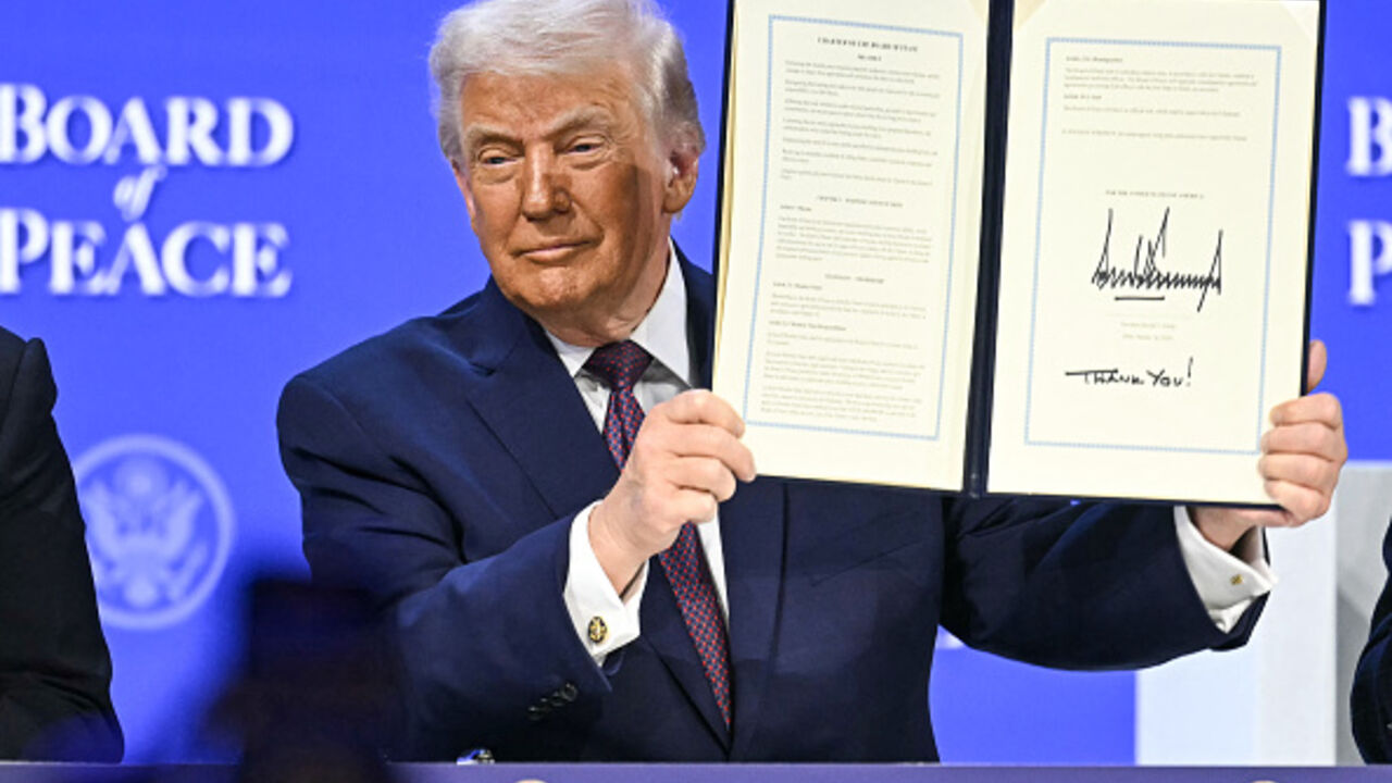 US President Donald Trump holds a signed founding charter at the Board of Peace meeting during the World Economic Forum (WEF) annual meeting in Davos on January 22, 2026. (Fabrice COFFRINI / AFP via Getty Images)