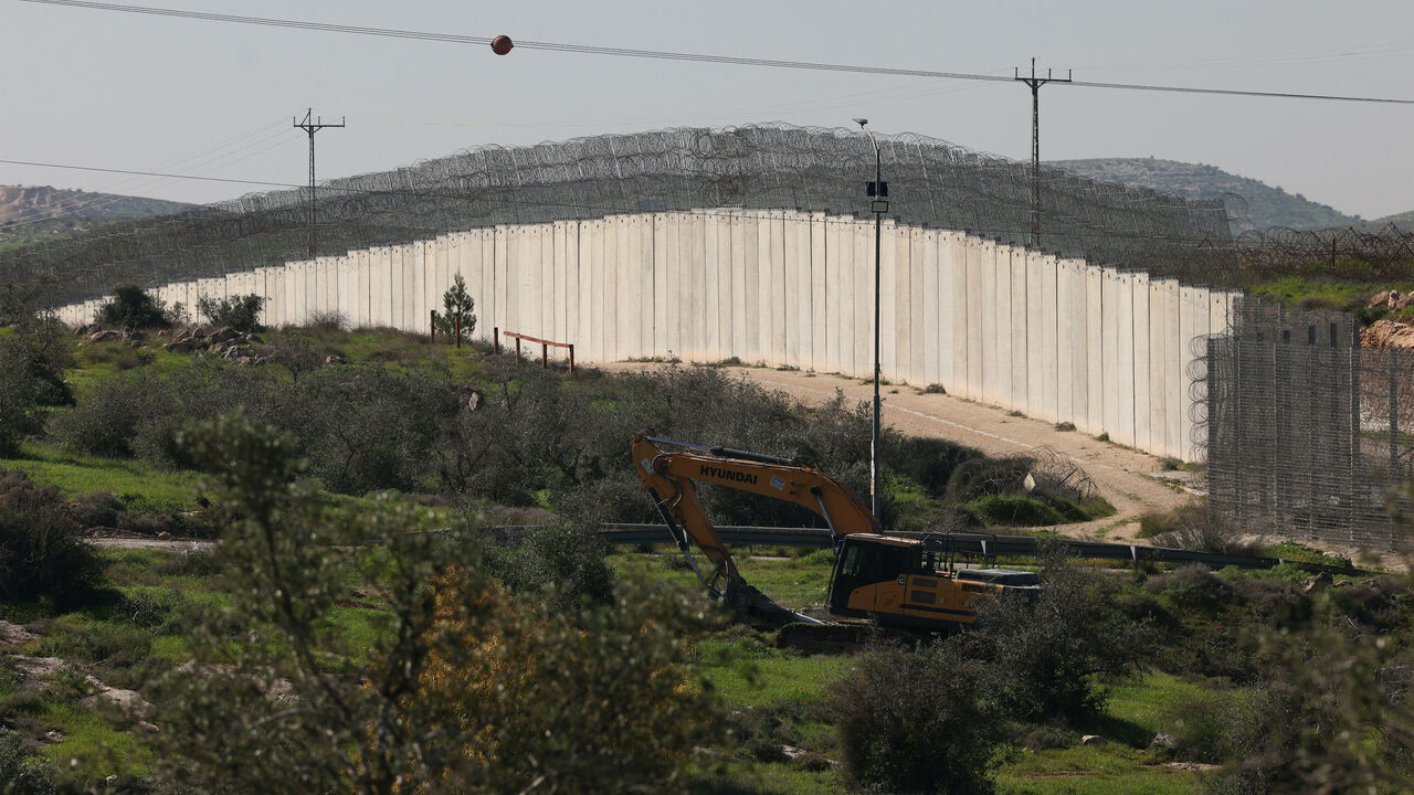 The Israeli built controversial separation barrier is seen passing through fields near the Palestinian village of Beit Aawa, west the Israeli-occupied West Bank city of Hebron on Feb. 5, 2026. 