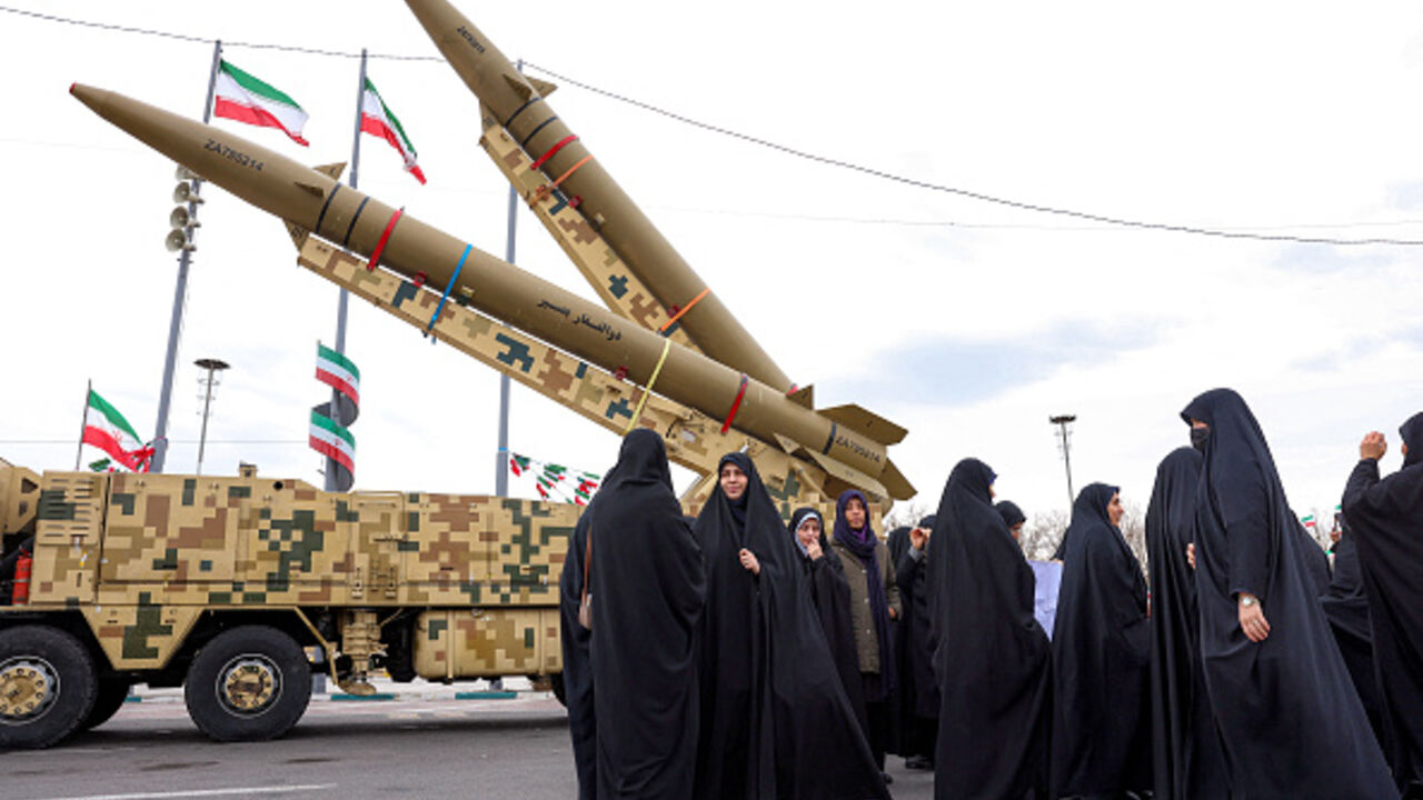 Women walk near ballistic missile launch vehicles in Tehran on February 11, 2026, during a rally marking the 47th anniversary of the 1979 Islamic revolution. (AFP via Getty Images)