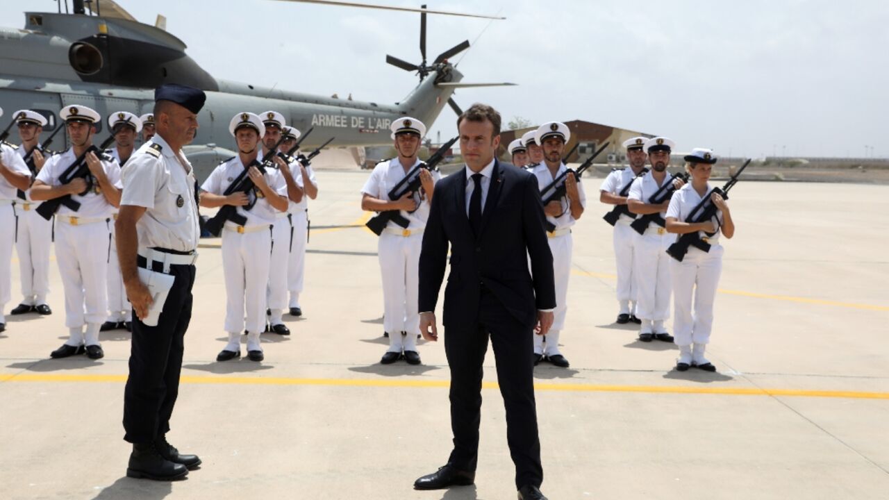 French president Emmanuel Macron (C) reviews the troops as he visits the French military base in Djibouti in 2019