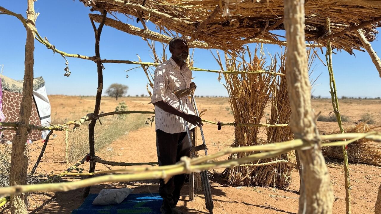 Ibrahim Noureldin leans on crutches at a makeshift shelter in the town of Tawila, Sudan 